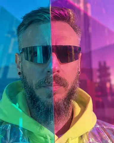 Head and shoulders of a bearded man seen through dichroic acrylic, half his face cyan and the other magenta