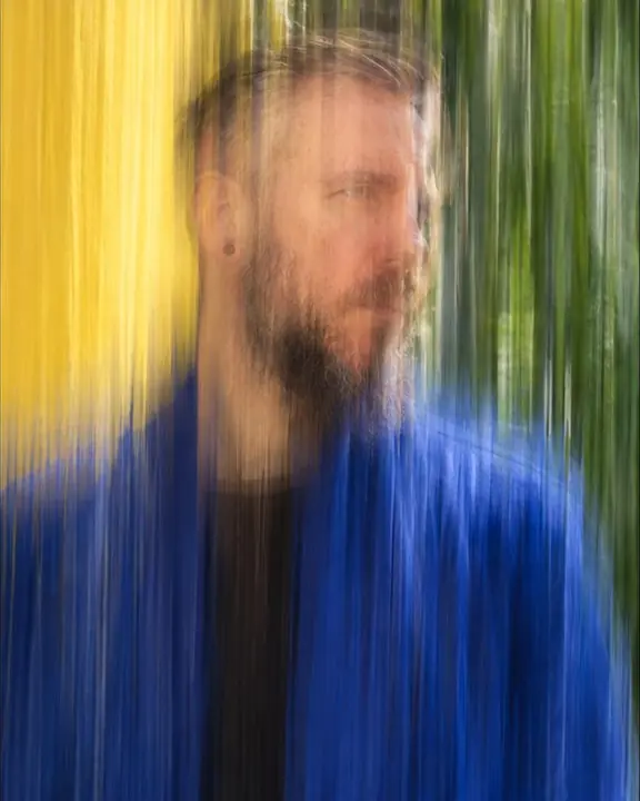 Half-length vertical streaks of a man in an ultramarine coat, his eyes and beard faintly holding