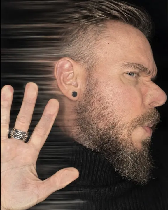 A bearded cheek on scanner glass in profile with one hand spread beside it, a stretched streak where the head moved