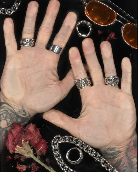 Hands with silver rings and chains pressed flat on scanner glass, every skin line in extreme detail