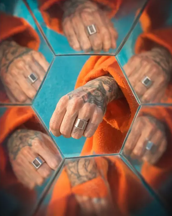 A silver ring and orange sleeve repeated into a geometric kaleidoscope pattern on a turquoise ground