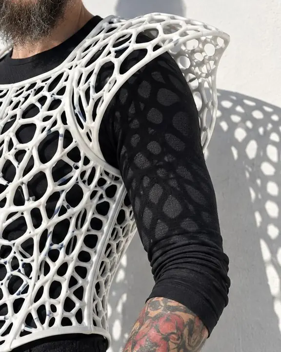 Close-up of a white printed lattice vest texture and its crisp shadow falling on a black sleeve