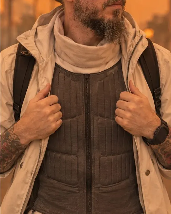 Close view of a slim cooling vest with fine channels and a soft filtration collar glowing in orange light