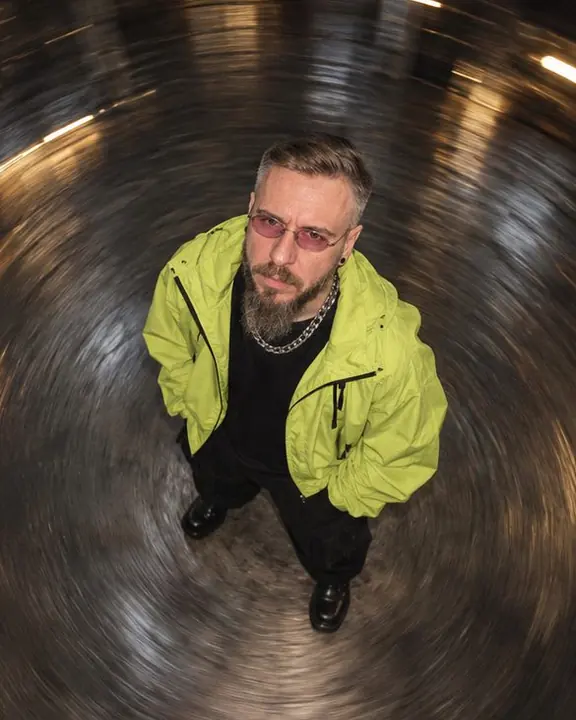 Angled view from above of a man standing still while the warehouse floor spirals around him