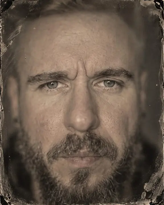 Close tintype portrait of a bearded man, eyes sharp, everything else falling into a soft swirl