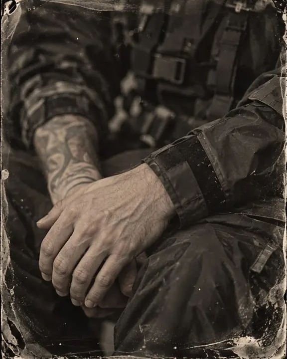 Hands with taped-seam jacket cuffs resting on a knee, collodion plate artifacts along the border