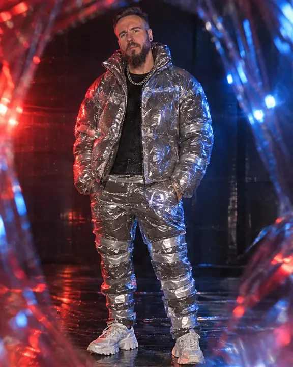Full-length man in a puffer jacket sealed in clear plastic film, its shine dissolving into red and blue color