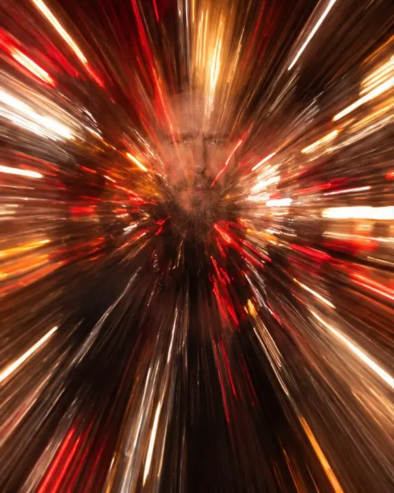 A frame of almost pure red and amber speed lines with a ghostly man's face at the center